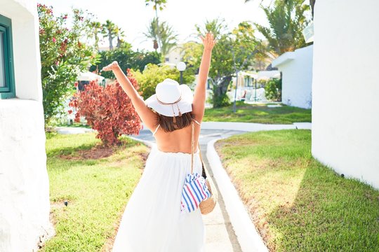 Young beautiful woman on white houses village walking on the streets on a sunny day of summer