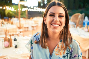 Young beautiful and elegant woman with wedding guest dress smiling happy and cheerful at party feast