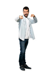 Fototapeta premium Full-length shot of Handsome man with beard points finger at you while smiling over isolated white background