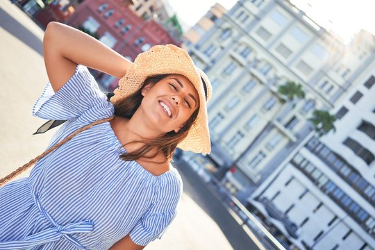 Young beautiful woman smiling happy walking on city streets on a sunny day of summer
