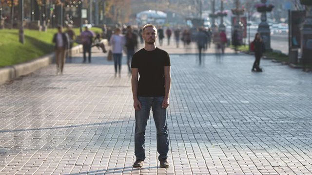 The man stands in the middle of crowded street. time lapse