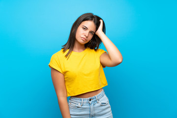 Young girl over isolated blue background with an expression of frustration and not understanding