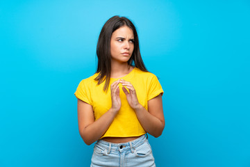 Young girl over isolated blue background scheming something