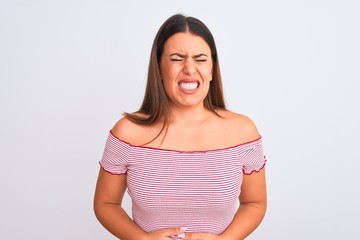 Fototapeta premium Portrait of beautiful young woman standing over isolated white background with hand on stomach because indigestion, painful illness feeling unwell. Ache concept.