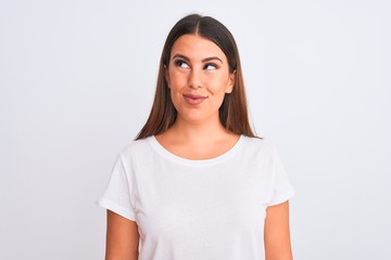 Fototapeta premium Portrait of beautiful and young brunette woman standing over isolated white background smiling looking to the side and staring away thinking.