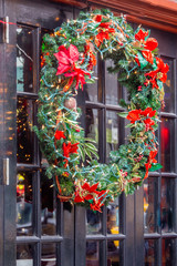 Festive Christmas wreath hanging on exterior glass door
