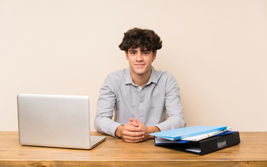 Young student man with a laptop keeping the arms crossed in frontal position