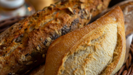 Diferent breads in a basket. Fresh Bakery with seeds and white bread  close up.