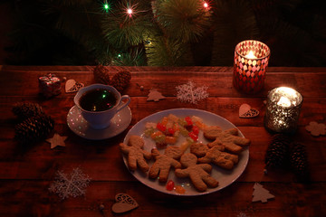 Christmas lights, tea, cookies and candles in candlesticks