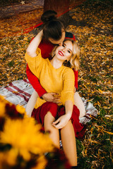 Romantic picnic of amazing couple in the park. Yellow and red colors. The moment of the kiss