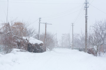 Obraz premium Winter, rural streets are covered with snow. Snow blizzard