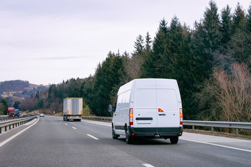 White Minivan in road. Mini van auto vehicle on driveway. European van transport logistics...