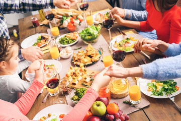 Family sitting at home, praying before dinner