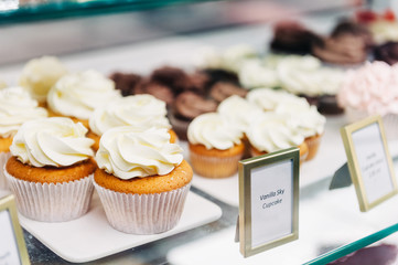 Shop window with vanilla cupcakes, bakery store