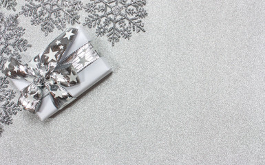 Christmas silver background with stars and a gift
