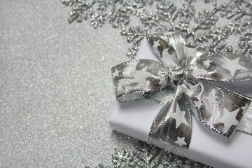 Bożonarodzeniowe srebrne tło z gwiazdkami i prezentem