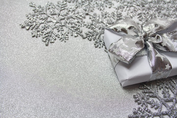 Christmas silver background with stars and a gift