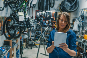 Female mechanic at work. Verify the checklist. Mechanic woman checking something on a tablet-pc and...