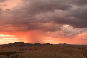 Fototapeta na wymiar Wolkenbruch im Abendrot in der Wüste Namib