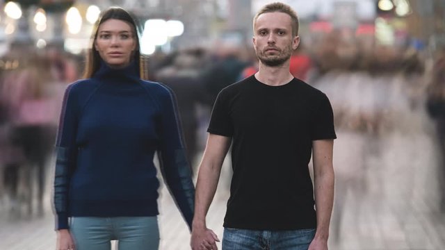 The couple stands on the megapolis flow background. time lapse