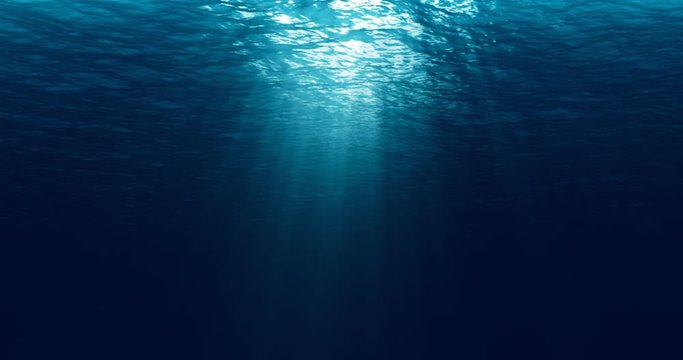 seamless loop of deep blue ocean waves from underwater background, light rays shining through
