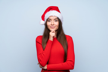 Girl with christmas hat over isolated blue background laughing