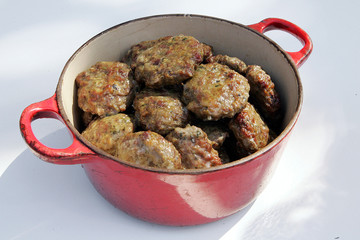 Fresh hot meatball appetizers served in red bowl.