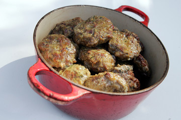 Fresh hot meatball appetizers served in red bowl.