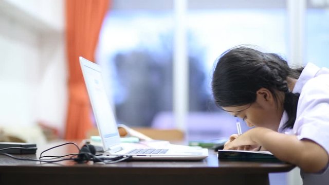Thai student to homework at the table in the living room on the evening