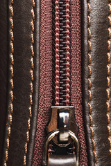 zipper of brown leather bag, close-up view