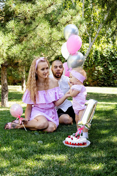 first year of life. birthday. happy parents. family photo shoot. cake. a party. holiday concept.