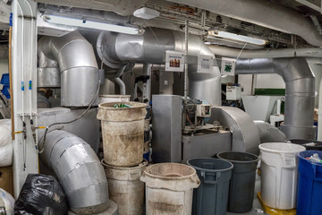 Recycling room with a lots of bins, incinerator. Garbage place onboard a cruise ship.