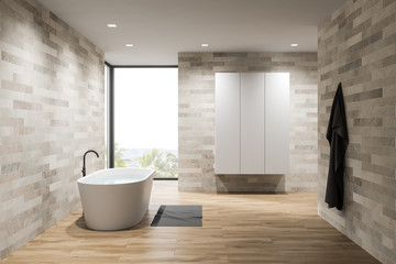 Fototapeta na wymiar Interior of light tile bathroom, tub and wardrobe