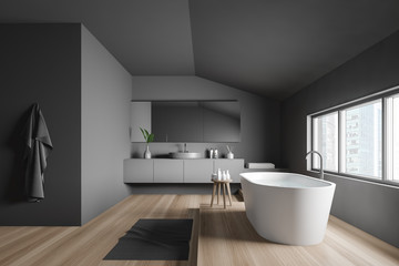Obraz na płótnie Canvas Side view of gray bathroom with tub and sink