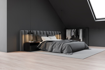 Gray attic bedroom corner with clothes