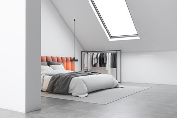 Attic bedroom corner with orange bed and clothes