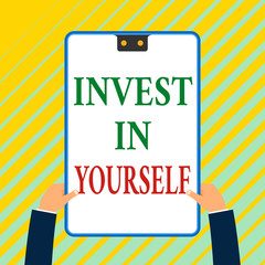 Writing note showing Invest In Yourself. Business concept for Improve your Skills take courses Do masters Scholarship White rectangle clipboard with blue frame has two holes holds by hands
