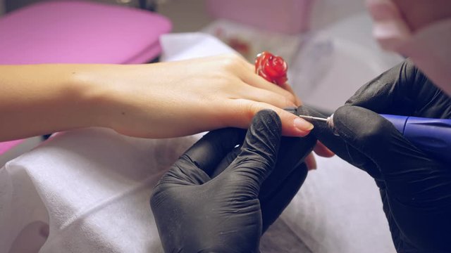 Manicure process. Correction of female nails with drilling machine