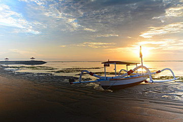 Sunrise scenic view in Bali, Indonesia with the traditional fishing boats at Sanur beach.