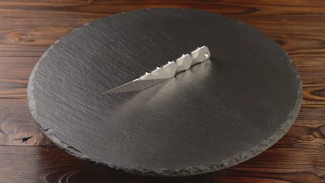 Custom hand crafted japanese kiridashi knife on the turning slate board table