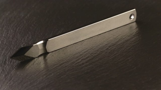Custom hand crafted japanese kiridashi marking knife for carpenter on the turning slate board table. Polished surface