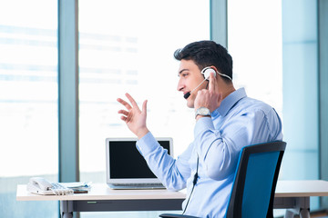 Male call-center operator in business concept