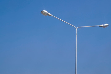 Street lighting bulb in daytime with blue sky close-up.