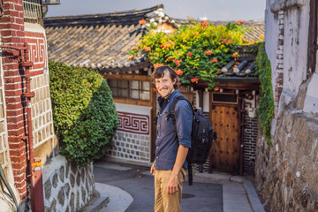 Young man tourist in Bukchon Hanok Village is one of the famous place for Korean traditional houses...