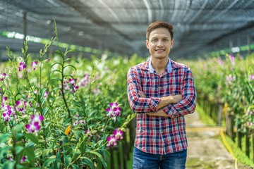 Portrait asian small business owner of orchid gardening farm, The purple orchids are blooming in...