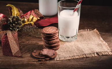 Stack of tasty chocolate biscuits cookies and a glass of milk on table