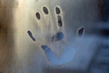 a handprint on the fogged glass