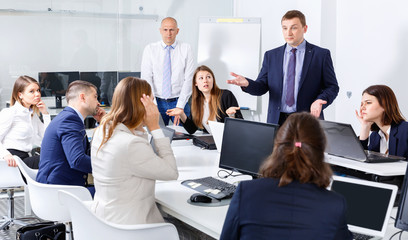 Businessman feeling angry to coworkers in office, pointing out mistakes in work