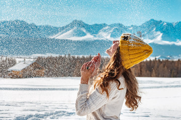 Happy young girl playing with snow