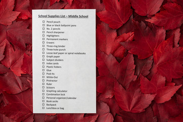 Back to school, school supplies list, middle school, on a bed of red fall leaves